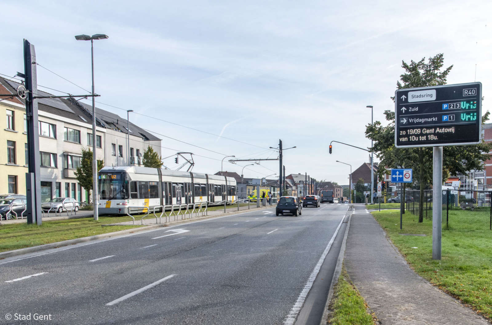 Tram passing through a Ghent city street with digital traffic signage