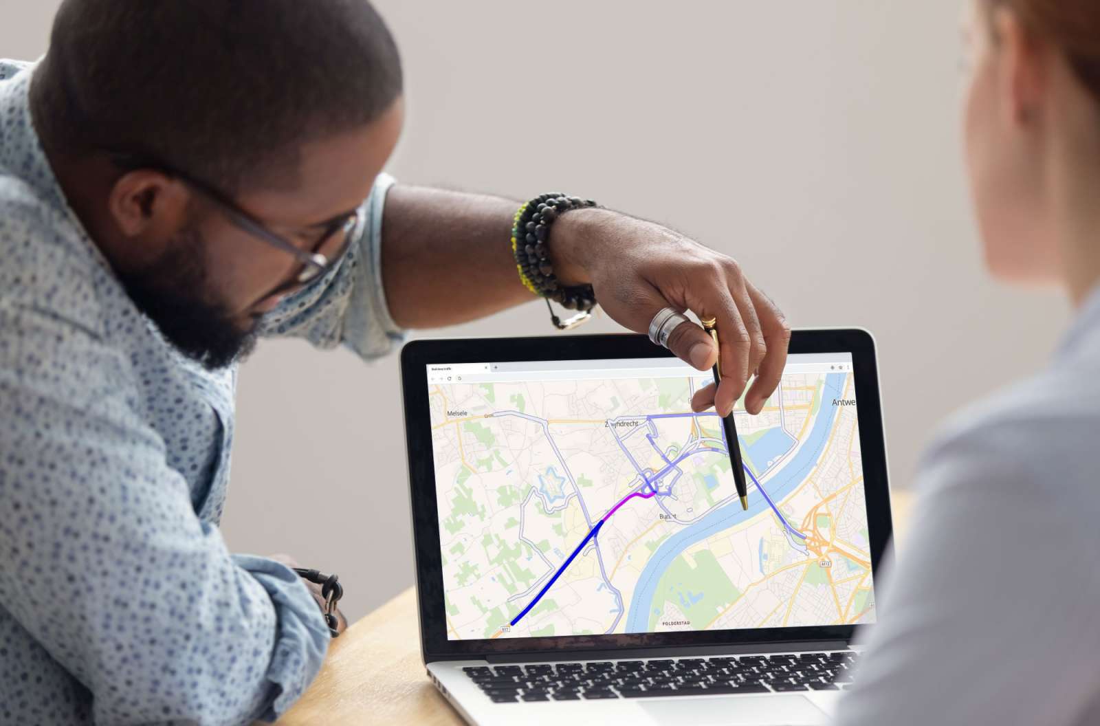 Two mobility specialists reviewing traffic flow patterns on a road network map