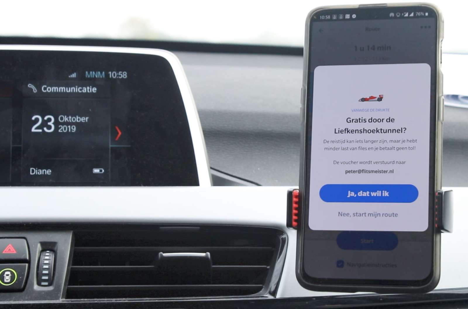 Smartphone in a car mount showing an offer for free passage through a tunnel