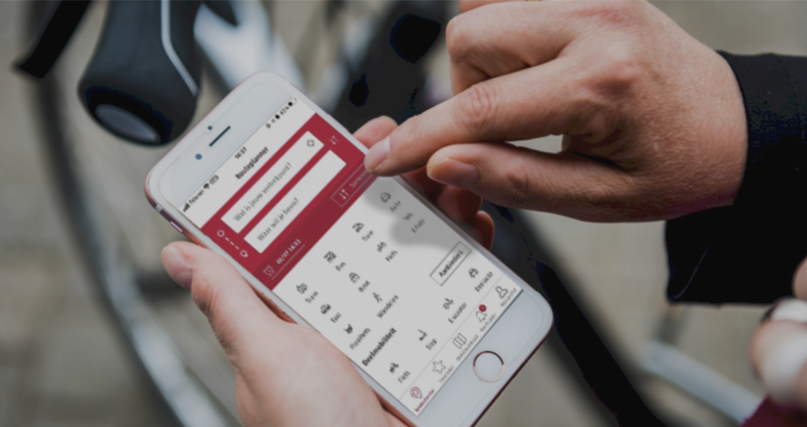 Close-up of a person planning a trip in a multimodal route planner on a smartphone