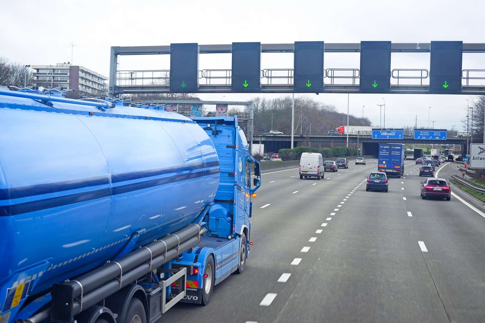 View from a truck cabin on a multi-lane highway with other freight vehicles ahead