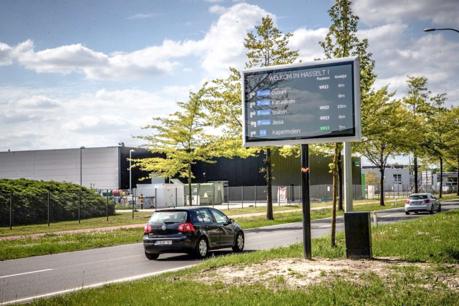 Roadside LED sign at the entrance of Hasselt showing available parking locations and travel times