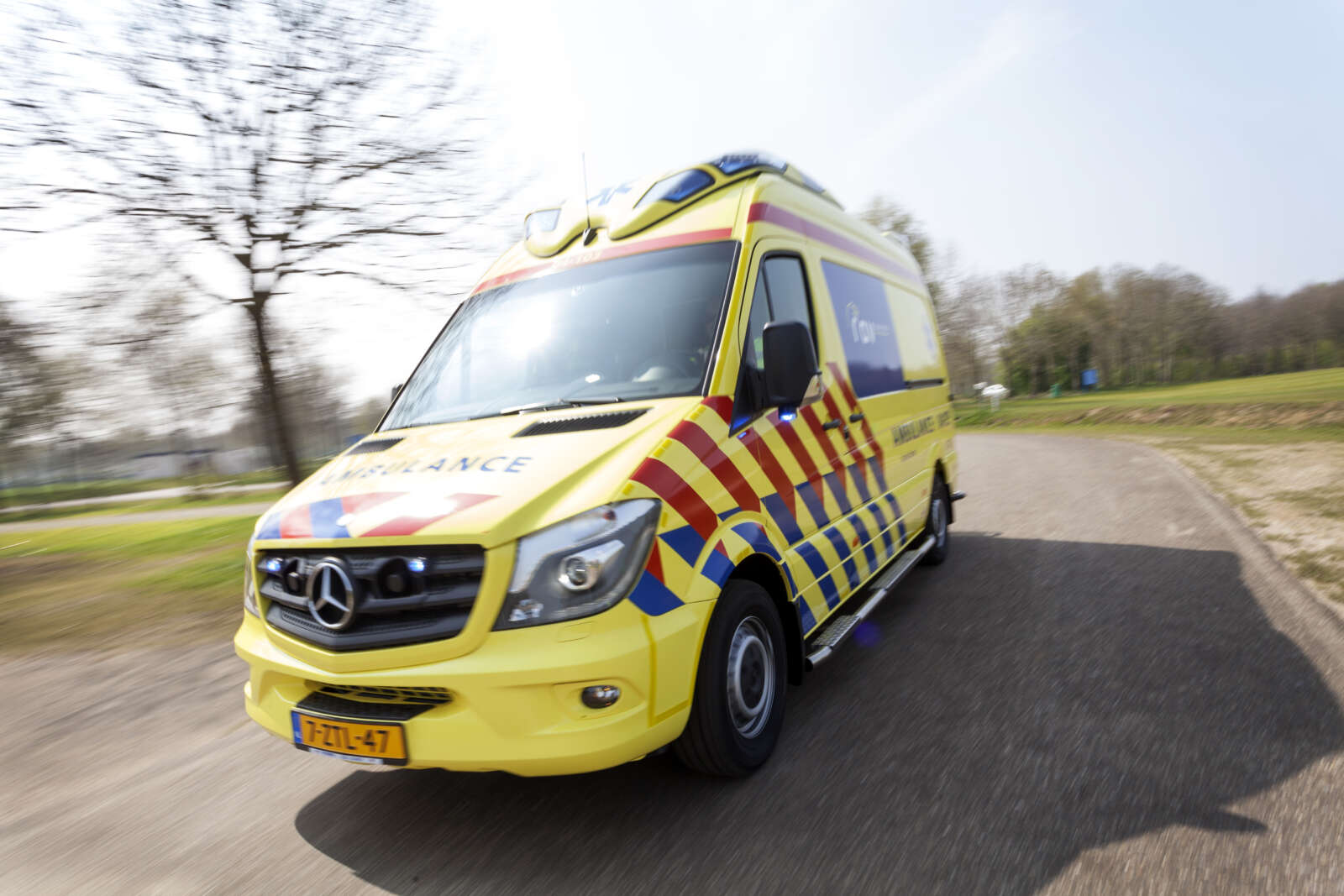 Ambulancezorg Nederland ambulance travelling on a road in the Netherlands.