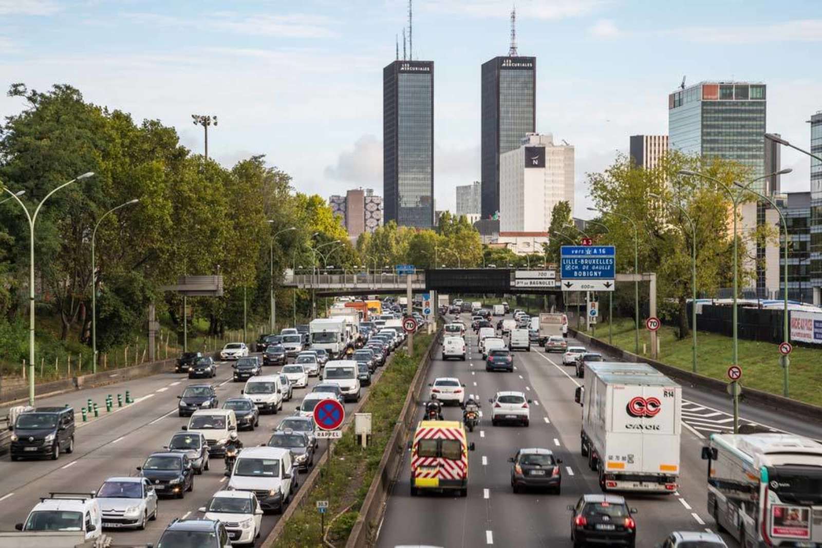 Busy multilane urban highway with high-rise buildings in the background