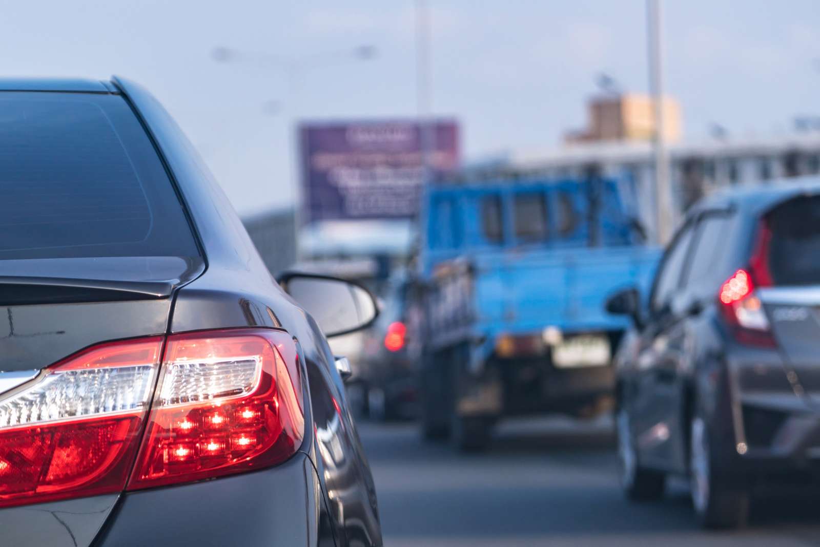 Close-up of red car tail lights in slow-moving traffic at dusk